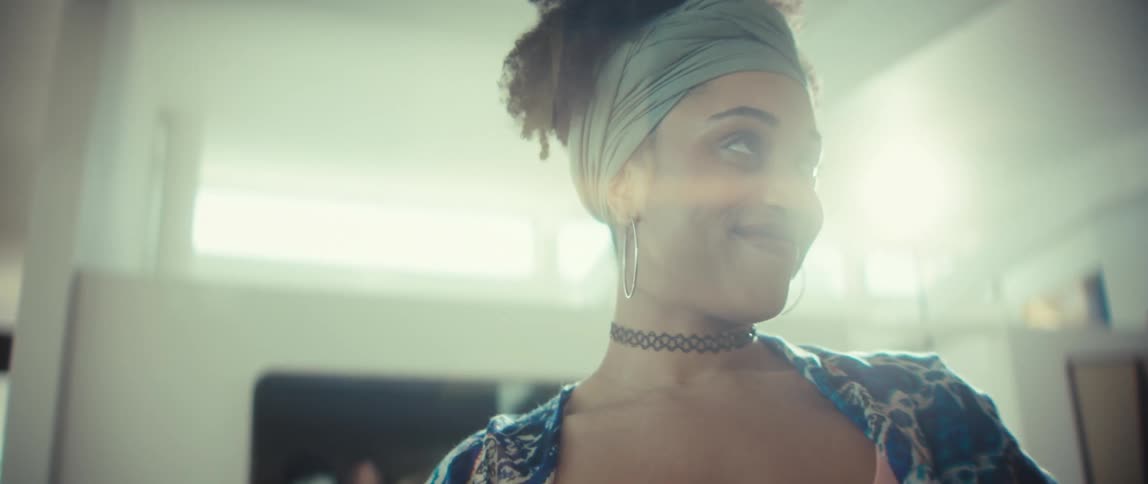 A stylish young Black couple smiles and dances lovingly together in their sun-drenched home in slow motion