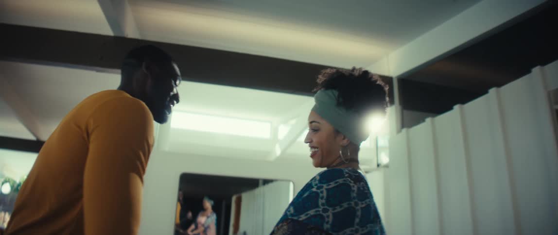 A loving Black couple shares a romantic, slow dance in their beautiful, sunlit home
