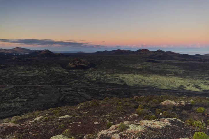 A stunning sunrise timelapse over a vast volcanic landscape as shadows sweep across the valley floor
