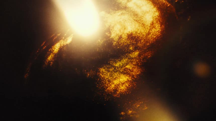 A golden, glittering galaxy slowly rotates in the vast darkness of space with a vintage film effect