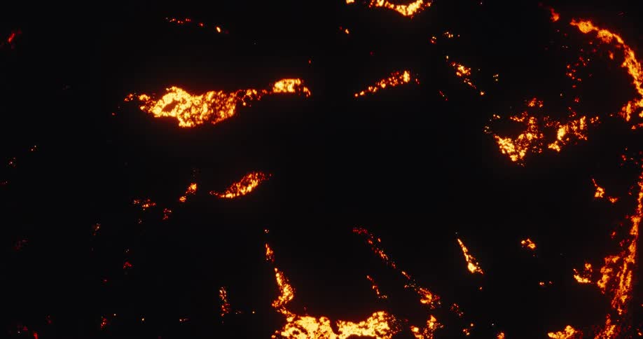 Top-down aerial shot of a mesmerizing glowing lava field slowly flowing and cooling in the darkness