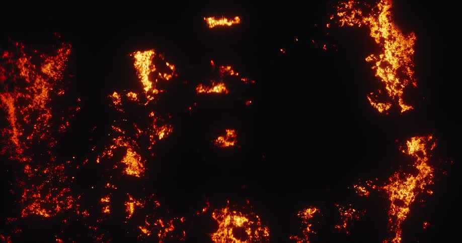 An intense top-down aerial view shows a fiery lava field flowing and glowing in the dark of night