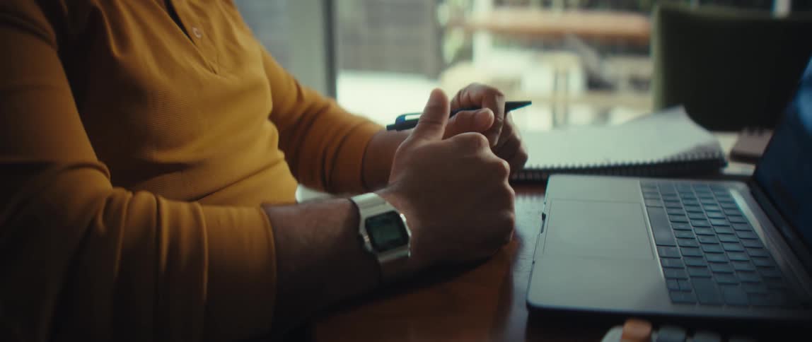 Close up of a person gesturing with their hands while explaining data shown on their laptop during a remote meeting