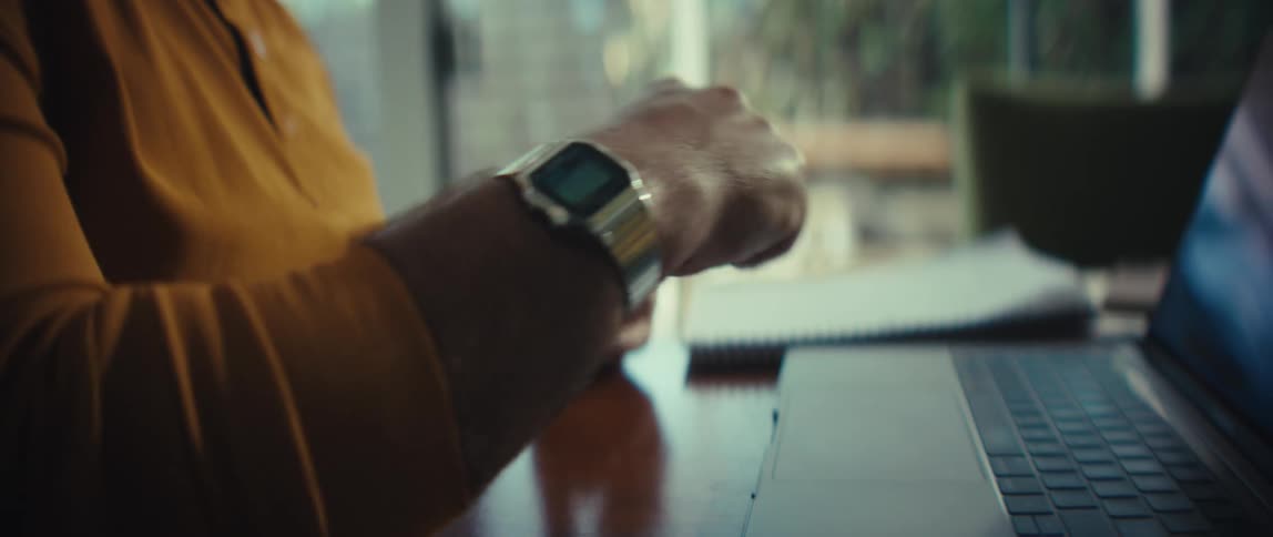 A bald businessman in glasses passionately explains his point, gesturing with his hands during a video conference call in a slow-motion close-up