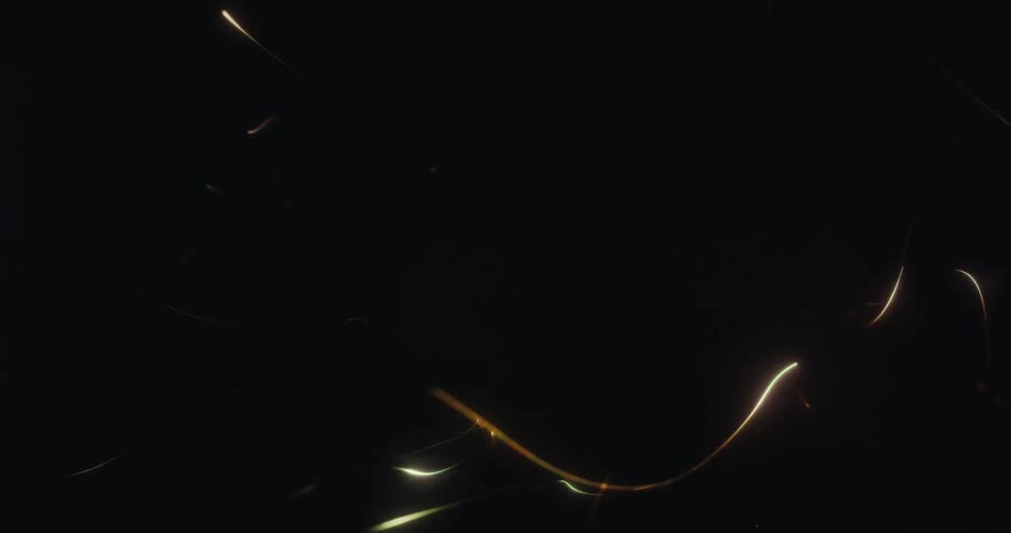 Abstract glowing light trails and energetic sparks fly chaotically across a dark, black background