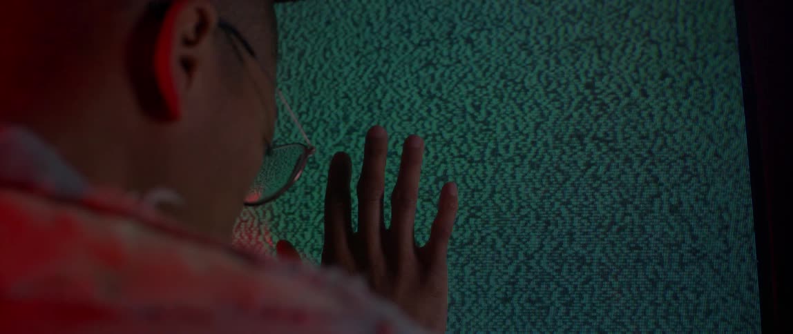A person is leaning against a television screen