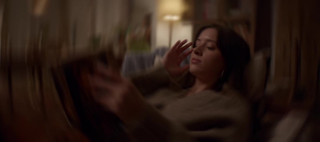 A young woman feels faint and dizzy, holding her head as the room spins in a blur around her