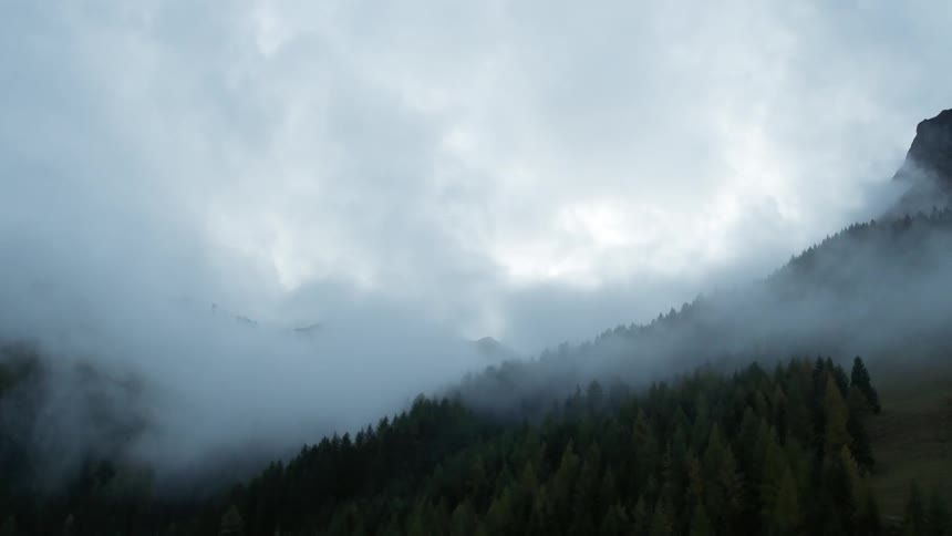 Clouds billowing over tall mountains