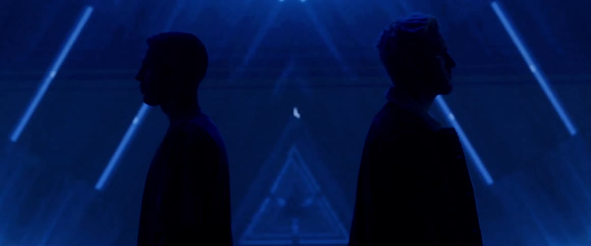 Two people are standing in front of a flashing light