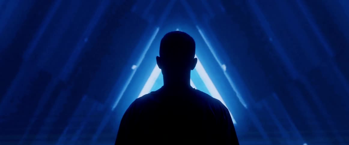 A silhouetted man stands in front of projected lights and animations
