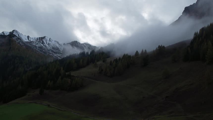 Clouds hover around a mountainside
