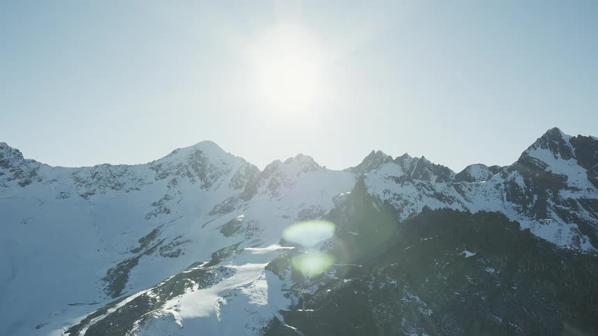 Sun shining over snowy mountain tops