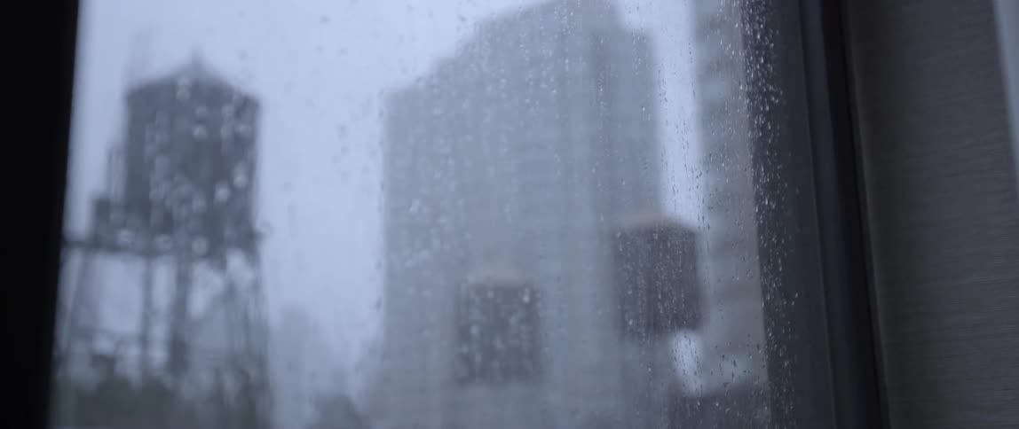 Raindrops on a window looking out at a city