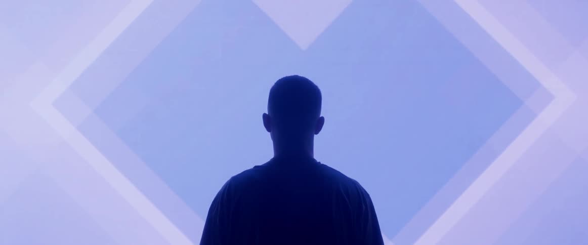A man stands in front of a flashing screen