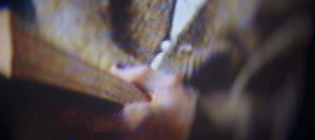 An extreme close-up of a digital display shows the individual pixels glowing with abstract colors