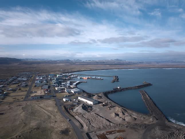 Slow aerial push-in over a remote fishing village and its harbor on the vast Icelandic coast