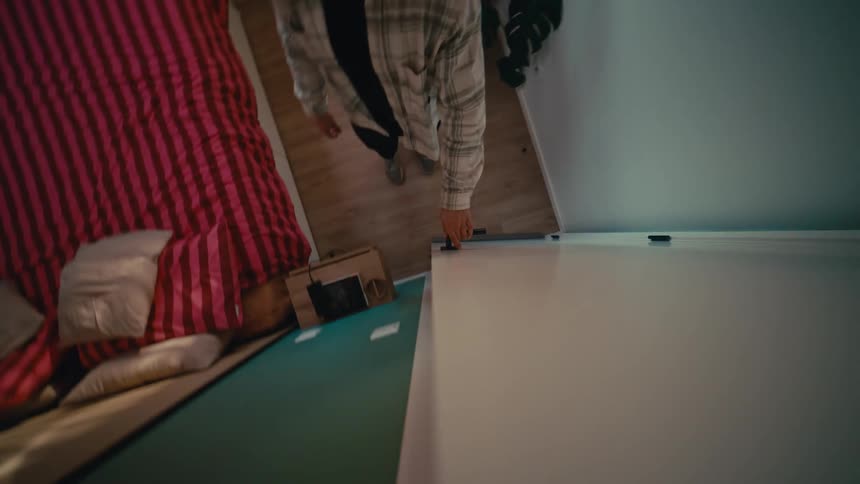 A unique top-down vertical perspective of a man opening a white door in a modern bedroom