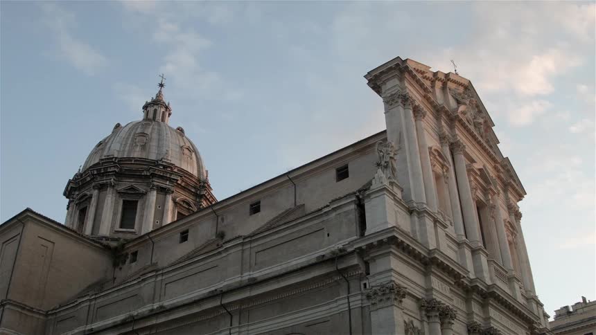 The large stone building has a cross at the top