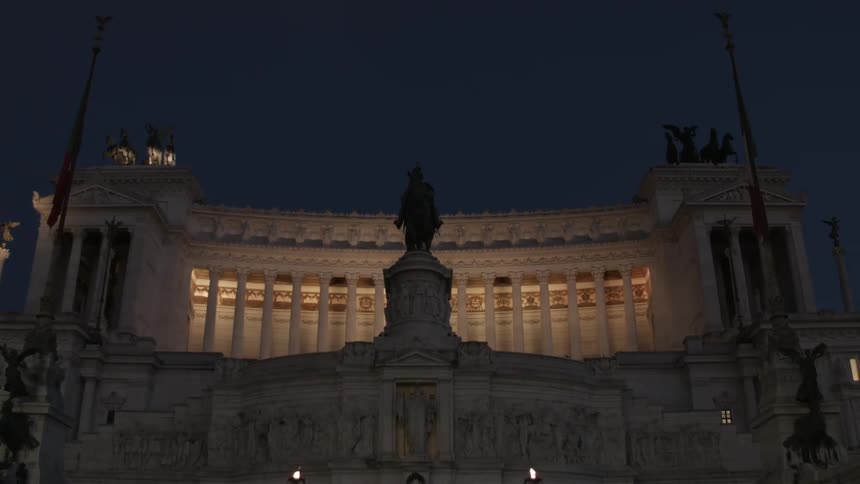 A statue in front of a well lit building
