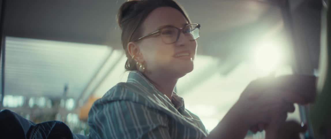 Low angle slow motion shot of a smiling woman in glasses shaking hands during a sunlit conversation