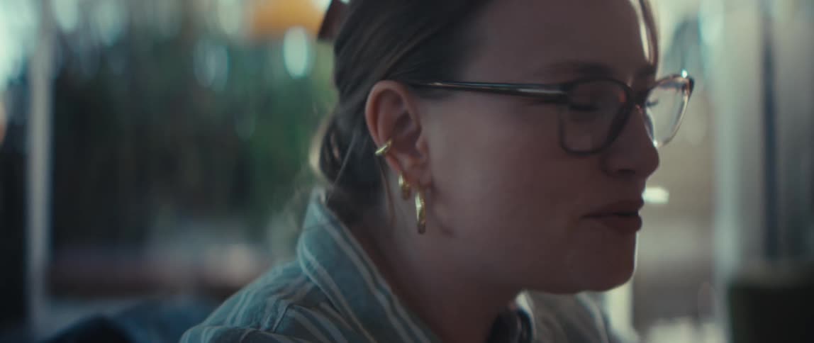 A tender close-up captures a moment of connection as three women hold hands in unity while sharing a joyful conversation