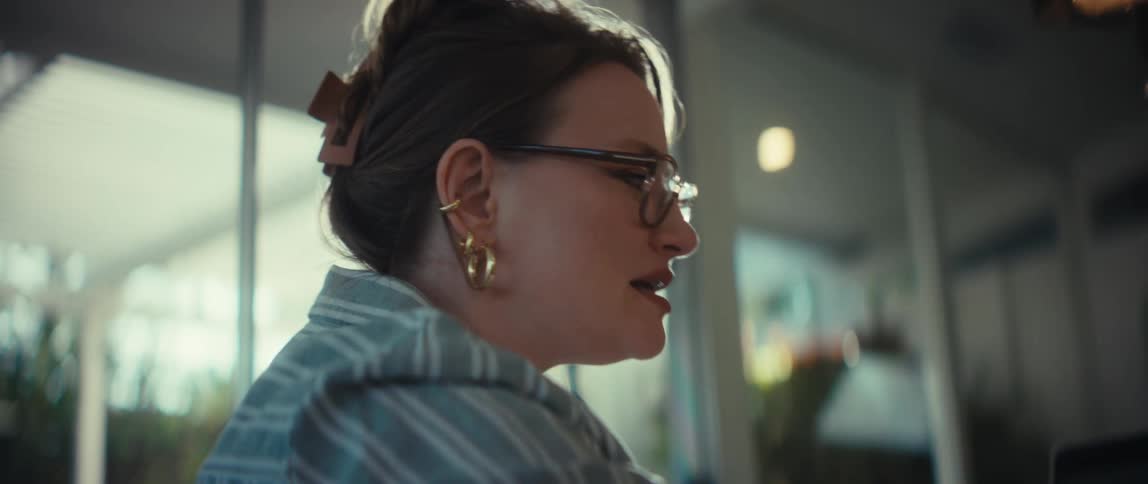 A caring young woman has a conversation with an elderly person in a sunlit room in slow motion