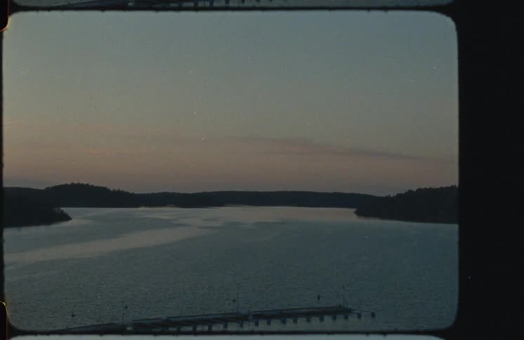 A vintage 8mm film effect transitions to a tranquil landscape of a lake and pier at dusk