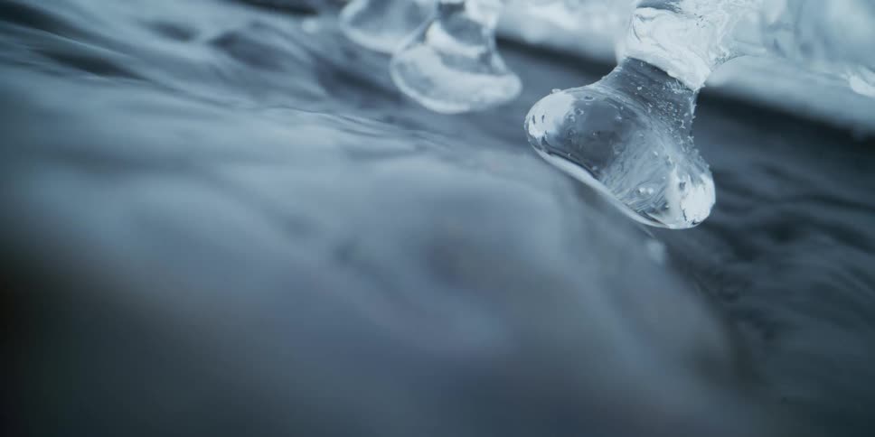Eerie macro shot of clear ice formations suspended over a rolling cloud of mystical white smoke