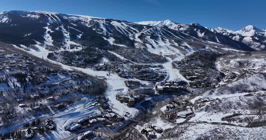 A stunning aerial view of the Snowmass ski resort in Colorado on a bright sunny day
