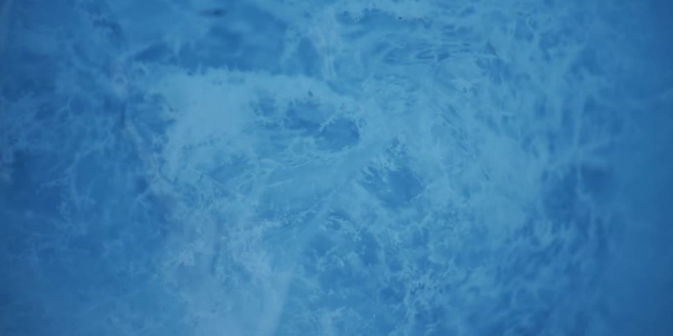 A macro view of ice crystallizing and spreading across a blue surface