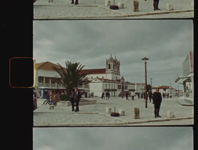 Nostalgic Super 8 film captures daily life in a European town square on a cloudy day