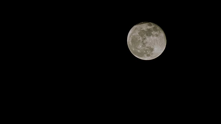 A detailed full moon sits alone in the upper right corner against a pitch-black night sky