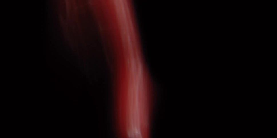 A subtle and organic red lens flare glows and shifts against a black background