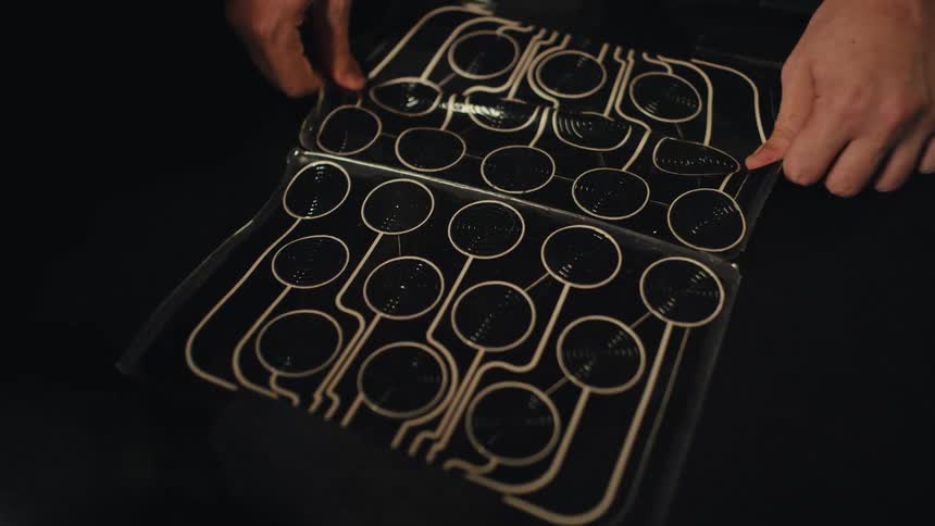 Close-up of a person examining a flexible myostimulator pad for electro muscle stimulation