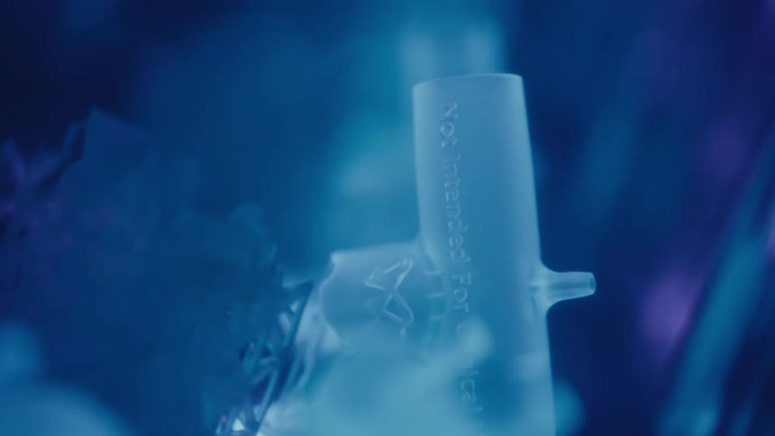 A sterile, translucent piece of medical equipment is shown in a mysterious blue light with swirling vapor