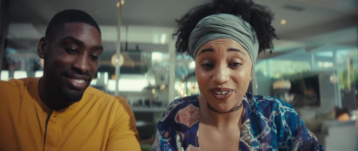 Slow motion shot of a cheerful young couple opening a laptop and enthusiastically discussing what they see on the screen