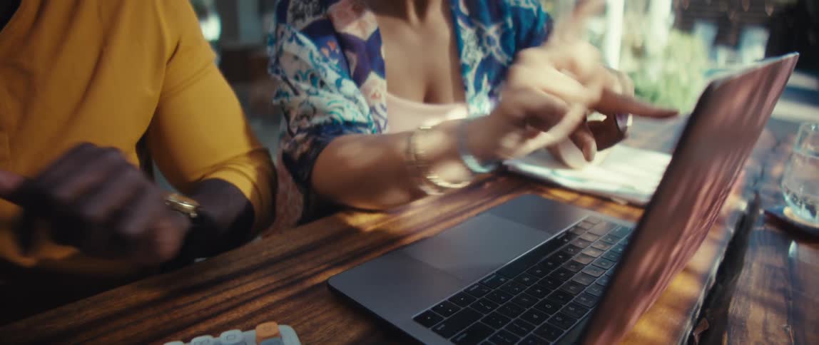 An enthusiastic couple works together on their finances or small business using a laptop and calculator