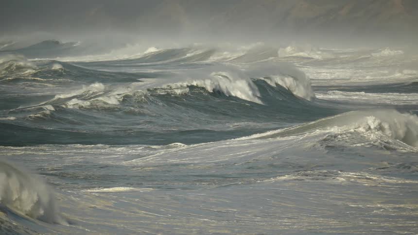 Powerful ocean waves crash and churn in slow motion during a violent storm