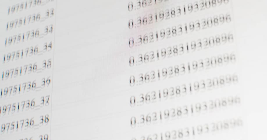 A close-up, out-of-focus shot of data scrolling quickly up a bright computer screen