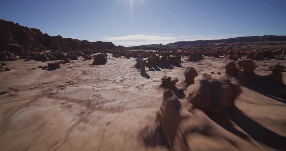 An exhilarating aerial journey ascends a canyon wall to reveal and fly through the otherworldly landscape of Goblin Valley, Utah