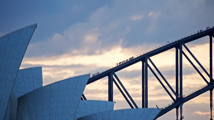 Iconic time-lapse of climbers silhouetted on the Sydney Harbour Bridge behind the Opera House at sunset