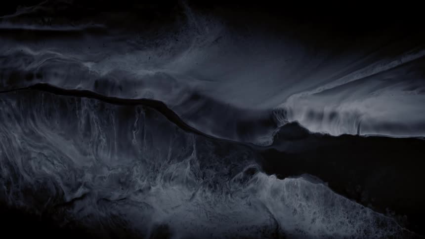 A mesmerizing dark abstract background of grey and black liquid ink slowly flowing and mixing