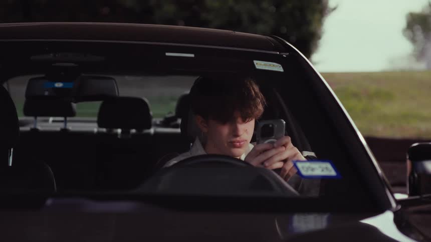 A distraught young man gets into his car, shows visible signs of stress and frustration, and then looks at his phone with a worried expression