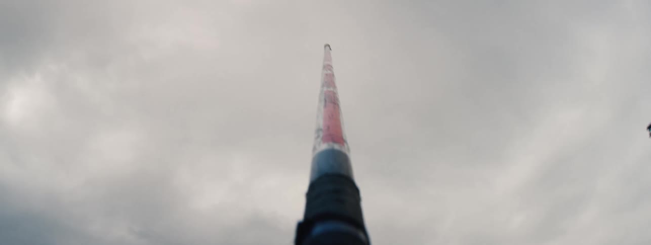POV of a javelin pointing to the sky as an athlete sprints down a track