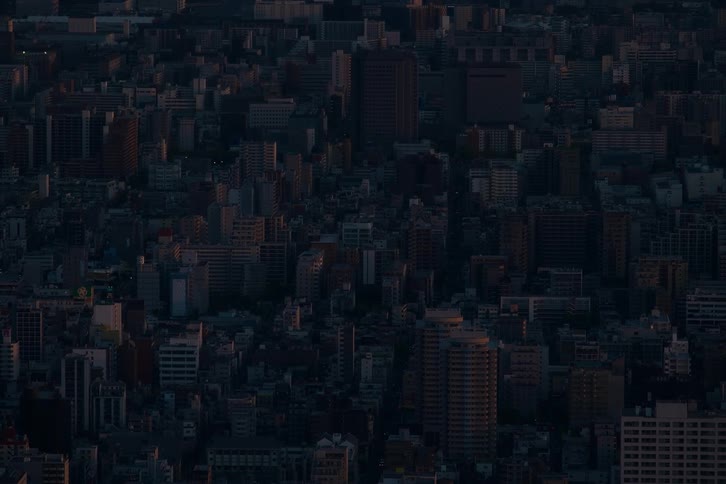 An expansive cityscape is bathed in the dim, early morning light just before sunrise