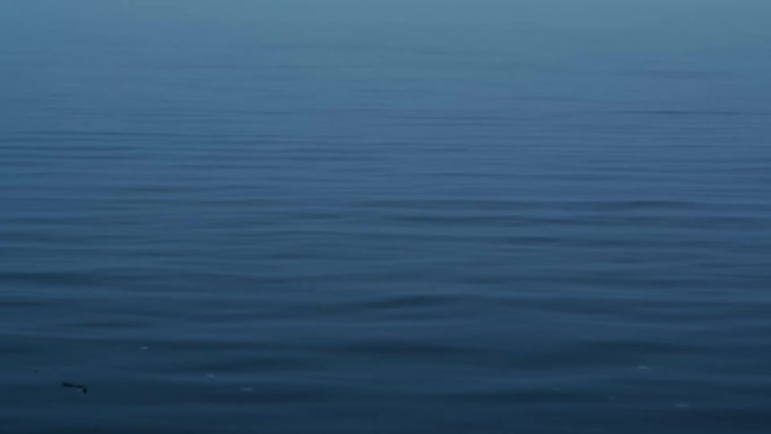 A peaceful, static view of gentle ripples on the surface of dark blue water