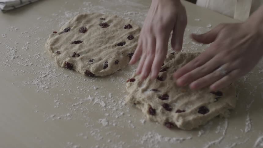 A person flattens two pieces of cookie dough