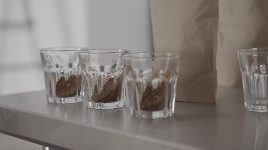 Glasses holding coffee grounds are sitting on a table-top