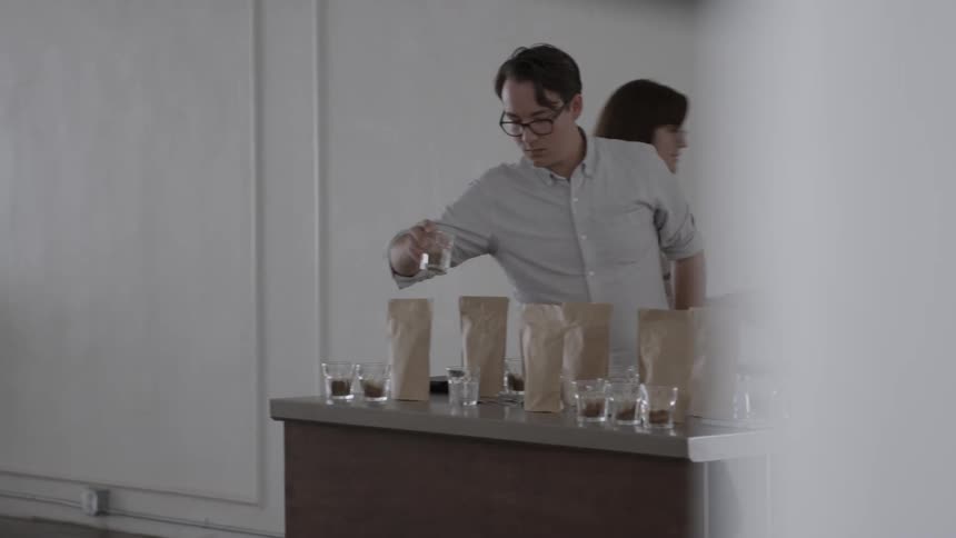 A man and woman prepare coffee drinks