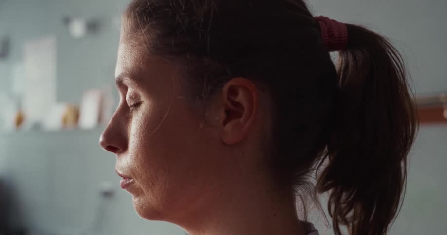 Close-up profile shot of a woman with her eyes closed in a calm meditative state